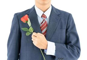 homme d'affaires en costume avec rose rouge sur blanc photo