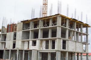 grand béton ciment moderne en construction nouveau bâtiment de maison monolithique moderne avec fenêtres, murs et balcons photo