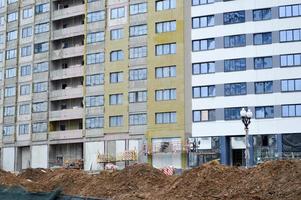 construction d'un grand bâtiment à plusieurs étages confortable en béton de ciment nouveau bâtiment moderne à plusieurs étages à ossature monolithique avec fenêtres, murs et balcons photo