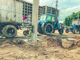 construction d'un nouveau microquartier en centre-ville. des tracteurs, des équipements pour la construction de bâtiments résidentiels se trouvent sur le site photo