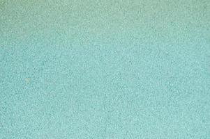 revêtement de sol en caoutchouc souple brillant bleu et jaune sans danger pour les sports et l'entraînement ou sur le terrain de jeu grâce aux nombreux petits cailloux ronds pressés. arrière-plan, texture photo