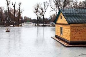 lac gelé avec pont et maison en bois photo