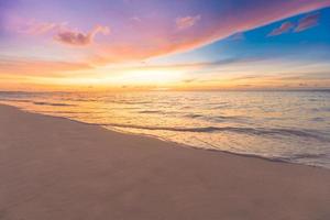 vue rapprochée majestueuse des vagues d'eau de mer calme avec la lumière du soleil orange au coucher du soleil. paysage de plage de l'île tropicale, côte exotique. vacances d'été, vacances nature incroyable pittoresque. paradis de la détente photo