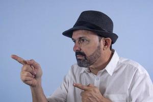 portrait d'homme barbu de 60 ans sur fond bleu photo