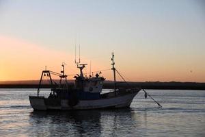 bateau de pêche en mer au coucher du soleil photo
