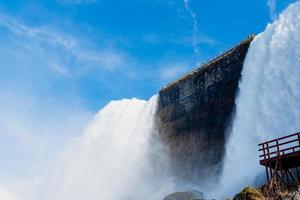 les chutes du niagara du côté américain et canadien. arc-en-ciel au-dessus de la cascade. l'endroit touristique le plus populaire. rivière orageuse qui se jette dans le lac. photo