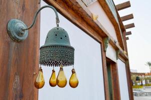 les bords de la cloche traditionnelle égyptienne du clocher sur le bâtiment avec des boules de verre brunes dégoulinent. décoration islamique arabe islamique des bâtiments photo