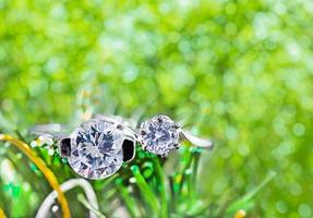 anneaux de mariage en diamant sur des feuilles vertes photo