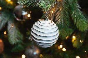 nouvel an de noël classique décoré arbre de nouvel an avec jouet et boule de décorations d'ornement blanc, lumières de guirlande défocalisés. conception de vacances classique moderne. réveillon de noël à la maison. photo