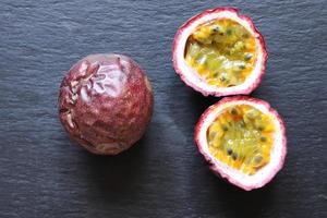 deux fruits de la passion, un entier, l'autre coupé en deux photo