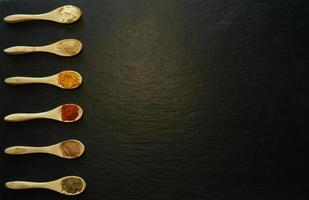 épices en poudre dans de petites cuillères en bois photo