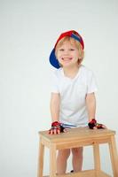 heureux garçon blond souriant. garçon dans une casquette. l'enfant sourit sur un fond blanc photo