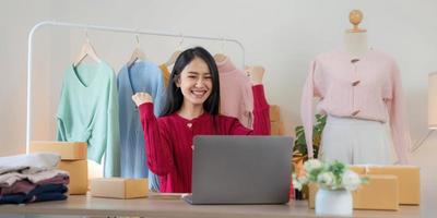 les femmes d'affaires de PME asiatiques utilisent un ordinateur portable pour vérifier les boîtes d'expédition en ligne des commandes des clients à la maison. démarrage d'une petite entreprise entrepreneur PME indépendant. entreprise en ligne, concept de travail à domicile. photo