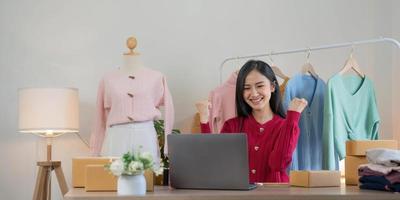 les femmes d'affaires de PME asiatiques utilisent un ordinateur portable pour vérifier les boîtes d'expédition en ligne des commandes des clients à la maison. démarrage d'une petite entreprise entrepreneur PME indépendant. entreprise en ligne, concept de travail à domicile. photo