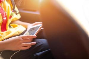 une écolière regardant son téléphone tout en conduisant une voiture privée sur le chemin du retour, mode de vie, vie éducative photo