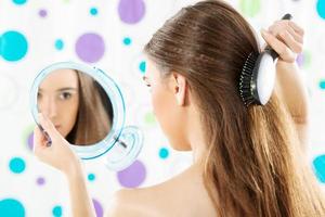 fille avec un miroir se peignant les cheveux photo