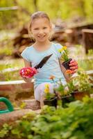 jolie petite fille plantant des fleurs photo