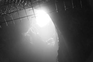 grotte rocheuse avec trou à travers lequel la lumière brille. mondes souterrains en suède. mystique photo