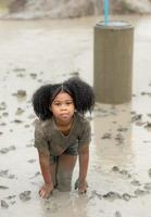 les petites filles s'amusent à jouer dans la boue dans les champs communautaires photo