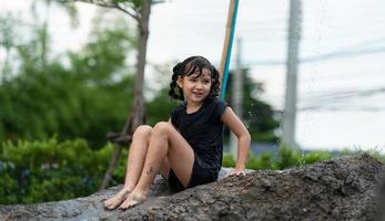 les enfants s'amusent à jouer aux toboggans de boue dans les champs communautaires. photo