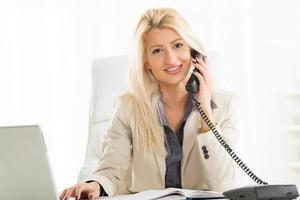 femme d'affaires blonde téléphonant au bureau photo