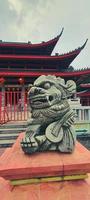 une photo d'une petite statue de dragon en pierre au semarang du temple sam poo kong.