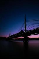 silhouette du pont sur l'eau calme à l'heure bleue photo