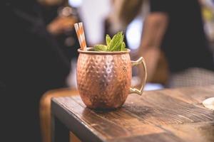 Tasse à cocktail en cuivre sur table en bois photo