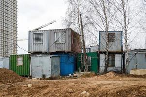 petites maisons temporaires de constructeurs à partir de conteneurs sur un chantier de construction industrielle. ville de construction modulaire en blocs avec vestiaires pour les travailleurs photo