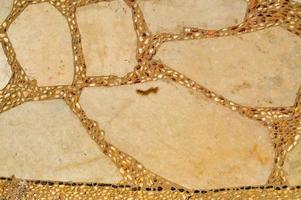 texture d'un mur de pierre, routes de pierres, briques, pavés, tuiles avec coutures sablonneuses de vieux jaune naturel gris ancien avec des arêtes vives. l'arrière-plan photo