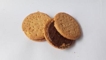 Une pile de délicieux biscuits ronds de blé fourrés au chocolat isolés sur fond blanc photo