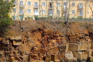 un bâtiment à plusieurs étages se tenant sur une falaise d'un rivage rocheux photo