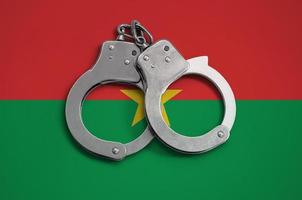 drapeau burkina faso et menottes de police. le concept de respect de la loi dans le pays et de protection contre le crime photo