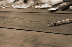 beaucoup de substances narcotiques et de dispositifs pour la préparation de drogues se trouvent sur une vieille table en bois photo