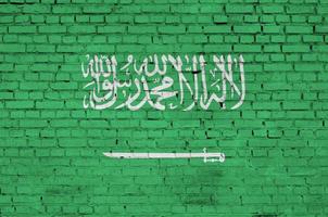 Le drapeau de l'Arabie saoudite est peint sur un vieux mur de briques photo