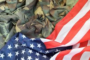 drapeau des états-unis d'amérique et veste d'uniforme militaire pliée. bannière de fond conceptuel de symboles militaires pour les vacances patriotiques américaines photo