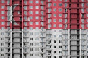 drapeau de singapour représenté dans des couleurs de peinture sur un immeuble résidentiel à plusieurs étages en construction. bannière texturée sur fond de mur de brique photo