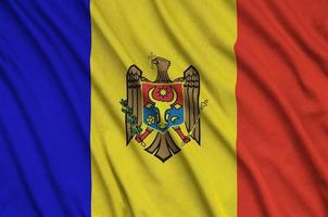le drapeau de la moldavie est représenté sur un tissu de sport avec de nombreux plis. bannière de l'équipe sportive photo