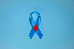 journée mondiale du diabète de sensibilisation au ruban bleu, 14 novembre. isolé sur fond bleu. espace de copie. vue de dessus photo