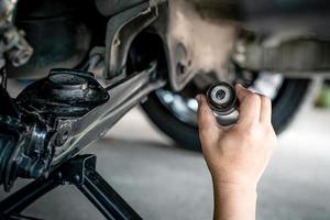 Close up hand a man hold old rubber bush and joint component part of car suspension in service shop and maintenance in service work photo