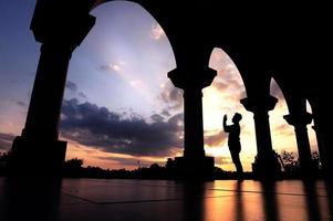 sangatta, bornéo oriental, indonésie, 2020 - un homme prie à l'extérieur de la mosquée sur fond de coucher de soleil photo