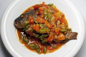 poisson frit avec sambal gami. cuisine traditionnelle indonésienne. le sambal gami est un sambal traditionnel de bontang, en indonésie. à base d'oignon rouge, piment, pâte de crevettes. photo