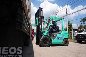 Sangatta, East Kalimantan, Indonésie, 2020 - conducteur de chariot élévateur chargeant l'expédition de palettes de fret avec une grue de camion à l'entrepôt de la zone de perking. photo