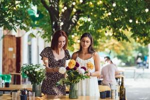 deux jeunes femmes composent un beau bouquet festif. photo