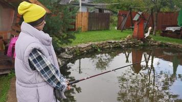 belle jeune femme pêche dans un petit étang photo