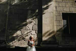 mariée posant sur fond de mur de pierre photo