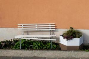 un banc en bois devant un mur de maison photo