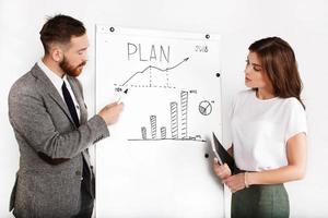 homme d & # 39; affaires et femme débat sur le graphique sur tableau blanc photo