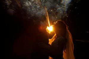 La lumière du soir brille derrière un couple de mariage dans le parc photo