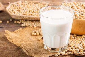 lait de soja dans un verre avec du soja sur une table en bois petit-déjeuner bio, riche en protéines, sain, produits agricoles, végétarien photo